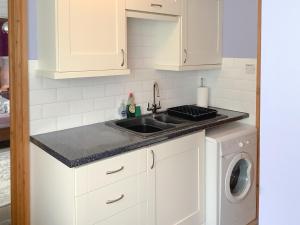 a kitchen with a sink and a washing machine at Newhouse Farm Barn in Neenton +15 photos