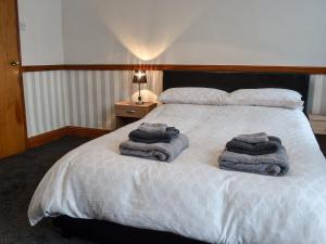 a bedroom with a bed with towels on it at Quarry Cottage in Bethesda