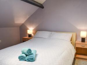 a bedroom with a bed with two towels on it at Quarry Cottage in Bethesda