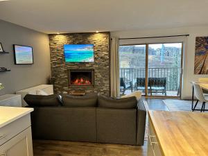 a living room with a couch and a fireplace at Updated 2 Bed 2 Bath Ski In Ski Out with King Beds, Hot Tub, Private Balcony in Steamboat Springs