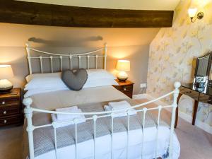 a bedroom with a white bed and two lamps at Granton Lodge in Far Sawrey +14 photos