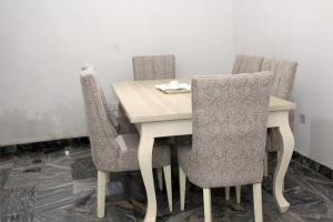 a dining room table with four chairs and a table and chairsuggest at Halal Fountain Hotel Kaduna in Kaduna