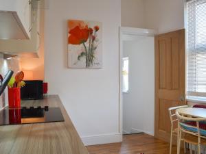 a kitchen with a table and a painting on the wall at Deja Blue in Filey