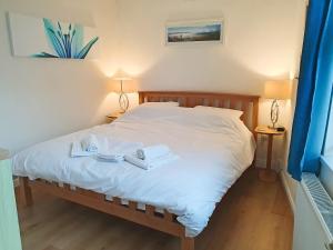 a bedroom with a bed with two towels and two lamps at Deja Blue in Filey +4 photos