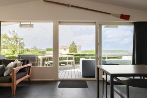 a living room with sliding glass doors and a table and chairs at Sternlaan 8 Kamperland in Kamperland