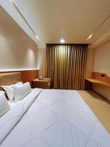 a large white bed in a room with a window at Nirvana Nest in Lucknow