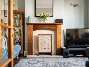 Una sala de estar con chimenea y televisión. en Turnstone House, en Gorleston-on-Sea