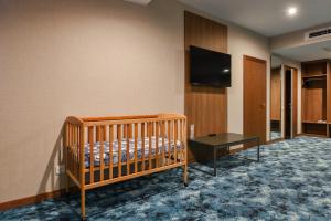 a crib in a room with a flat screen tv at Forward Club House 