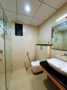 a bathroom with a toilet and a sink and a shower at Nirvana Nest in Lucknow