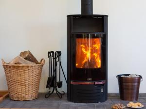 a wood burning stove with a basket next to it at Woodlands in Milverton +17 photos