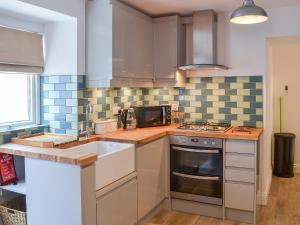una cocina con fregadero y estufa en Rosetta Apartments - Ocean Mist, en Newquay