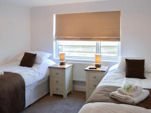 2 camas en una habitación con ventana y 2 velas en Rosetta Apartments - Ocean Mist, en Newquay 7 fotos más