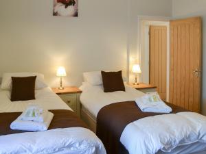 Una habitación con dos camas con toallas. en Rosetta Apartments - Ocean Mist, en Newquay