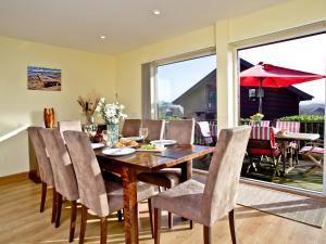 une salle à manger avec une table et des chaises en bois dans l'établissement Beech Lodge - Retallack Resort, à Saint Columb Major