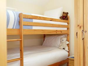 a bunk bed with a teddy bear sitting on the bottom bunk at Kentish Barn Retreat in Chilham