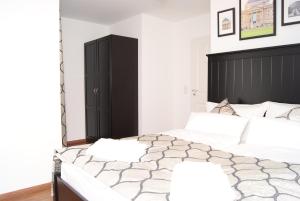 a bedroom with two beds and a black headboard at Merkel Villa Apartamente in Wiesbaden