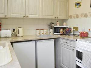 a kitchen with white cabinets and a counter top at Cosy Corner in Bessingby