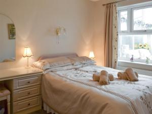 a bedroom with a bed with two teddy bears on it at Cosy Corner in Bessingby