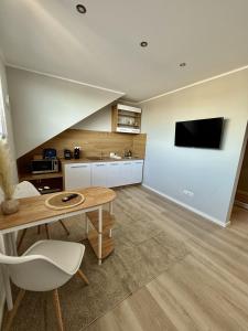 een woonkamer met een tafel en een tv aan de muur bij Twenty2 Apartments in Brühl