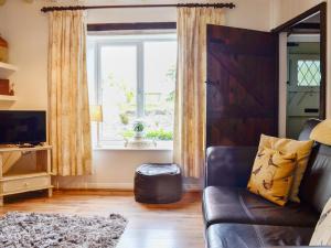 un soggiorno con un divano e una finestra di The Bellringers Cottage a Llandegla