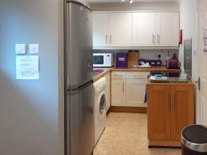 una cocina con refrigerador y lavadora y secadora en Seaview Cottage, en Bonnavoulin