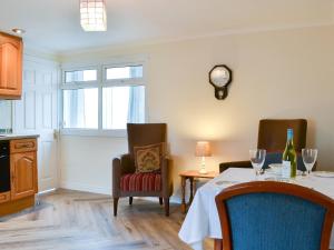 a dining room with a table and a clock on the wall at Lorna's At The Grange - Uk11565 in Mockerkin