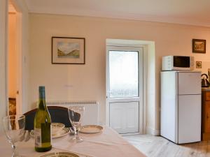 a kitchen with a table with a bottle of wine at Lorna's At The Grange - Uk11565 in Mockerkin