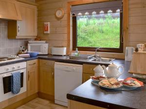 una cocina con fregadero y una barra con comida. en The Brown House, en Woolfardisworthy