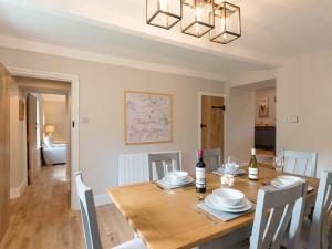 a dining room with a wooden table and chairs at Abraham's Cottage in Low Eskcleth