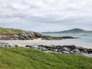 einen Strand mit Felsen und dem Meer an einem wolkigen Tag in der Unterkunft Kilbride Cottage in Pollachar