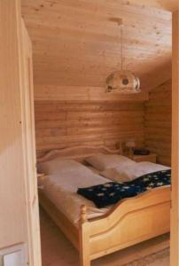 una camera da letto con un letto in una stanza di legno di Ferienhaus Blommen In Falkertsee a Falkertsee Altre 8 foto