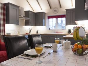 einen Tisch mit zwei Gläsern Orangensaft darauf in der Unterkunft Kingfisher Cottage in Wainfleet All Saints