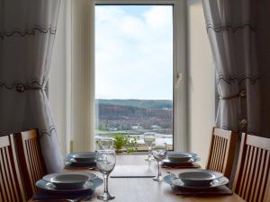 a table with glasses and plates on it with a window at Tote Cottage in Skeabost