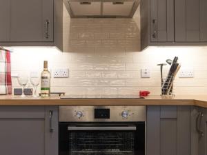 eine Küche mit einem Herd und 2 Gläsern Wein in der Unterkunft Kingfisher Cottage in Wainfleet All Saints