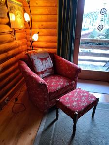 una sedia e uno sgabello in una stanza con finestra di Ferienhaus Blommen In Falkertsee a Falkertsee