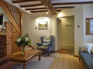 a living room with a couch and chairs and a table at The Lovely Old Cottage in Stratford-upon-Avon