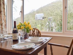ein Tisch mit einer Flasche Wein und einem Fenster in der Unterkunft Tucking Cottage in Treffgarne + 23 Fotos