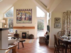 ein Wohnzimmer mit Kamin und Tisch in der Unterkunft Tucking Cottage in Treffgarne
