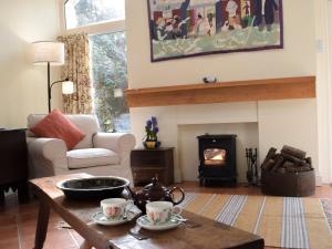 ein Wohnzimmer mit Tisch und Kamin in der Unterkunft Tucking Cottage in Treffgarne