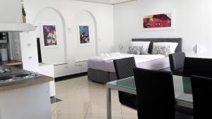 eine Küche und ein Wohnzimmer mit einem Bett und einem Tisch in der Unterkunft Villaci Business Apartments in Leimen