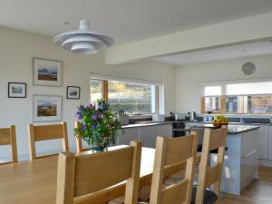 a kitchen with a table with a vase of flowers on it at Rowan House in Fiskavaig