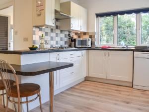 eine Küche mit weißen Schränken und einer Arbeitsplatte in der Unterkunft Caddie - Uk11038 in Carlyon Bay