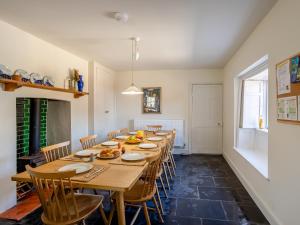 a dining room with a long table and chairs at The Retreat - M in Burton Bradstock