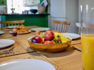 a wooden table with a bowl of fruit on a table at The Retreat - M in Burton Bradstock
