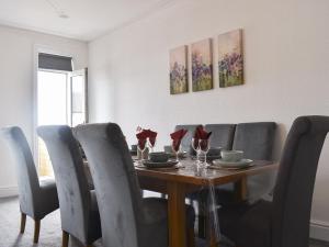 Un comedor con mesa y sillas de madera. en South Side - Apartment, en Bridlington