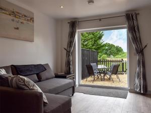 a living room with a couch and a sliding glass door at Oak - Uk11993 in Greenhill