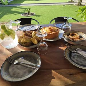 a wooden table with plates of food on it at Jugendstil Villa - 2 min zum Meer in Figueira da Foz