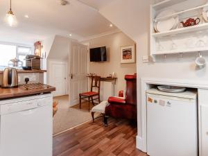 una cucina con armadi bianchi e una sedia rossa di Forth Reflections a Queensferry