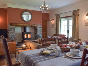 a living room with a table and a fireplace at Swn-Y-Don in Llanstephan