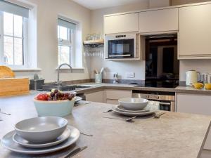 a kitchen with two bowls and a bowl of fruit on a counter at Duck Cottage in Tholthorpe